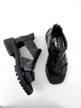 Sandalias negras de cuero con textura escamada, con plataforma y cierre trasero vertical.