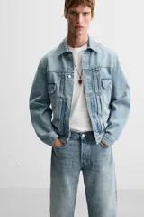 Pantalón de jean gris de corte recto, con cinco bolsillos, efecto lavado y cierre frontal con botones.