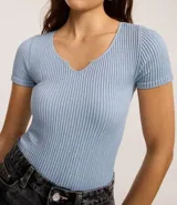 Body celeste de poliamida seamless con textura acanalada, cuello en V, mangas cortas y cierre en la entrepierna.