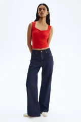 Top corto sin mangas color rojo, de punto suave y ajuste ceñido. Presenta escote corazón profundo y costura fruncida en el centro del busto.