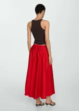 Falda midi roja de corte evasé con diseño de tablas y cierre de cremallera invisible en el lateral.