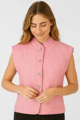 Chaleco rosa acolchado con cuello mao, cierre frontal con botones metálicos y bolsillos delanteros.