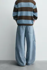 Pantalón de jean celeste de corte holgado y amplio en toda la pierna, tiro medio, tejido rígido, cinco bolsillos, efecto lavado, parche en trasero y bolsillo de vivo en pernera.
