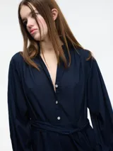 Vestido midi azul marino con botones en el escote y lazo ajustable en la cintura.
