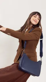 Bandolera negra de simil cuero con cierre trasero y división interna. Incluye correa de galón ajustable.