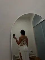 Vestido largo blanco elastizado con sobre falda asimétrica y estilo corset en la espalda.