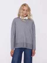 Sweater gris de tejido de punto con terminación en lurex y cuello camisero blanco.