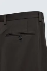 Pantalón de vestir negro de lana, corte recto, con bolsillos laterales y traseros de ojal con botón.