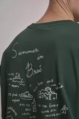 Remera verde oscuro de corte oversize con estampado pequeño en el frente.