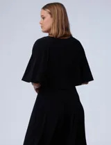 Vestido midi negro con corte a la rodilla, de seda fría, con capa superior superpuesta y mangas cortas.