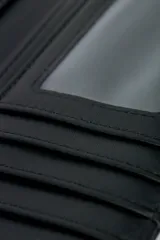 Billetera negra con textura símil cuero, cierre con broche imán y espacio para 13 tarjetas. Cuenta con 3 bolsillos para billetes, uno con cierre.