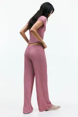 Pantalón recto color rosado, de punto con efecto arrugado, con elástico y cordón ajustable en la cintura.