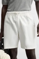 Bermuda negra regular fit confeccionada en tejido de algodón con estructura. Cintura elástica ajustable con cordón, bolsillos laterales y bolsillo trasero de vivo.
