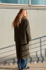 Trench color verde oscuro con cuello solapa combinado en pana marrón y manga larga. Detalle de acabados con trabillas y pinza en espalda. Bolsillos delanteros con solapa y botón a presión. Tejido encerado efecto lavado. Cierre frontal con botones a presión.