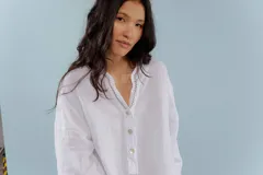 Camisa celeste de lino con escote en V y bordado multicolor en el cuello.