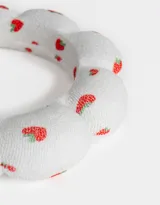 Vincha rígida de toalla blanca con estampado de frutillas rojas.
