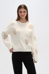 Sweater color crema de tejido de punto con apliques de corazones en color beige.
