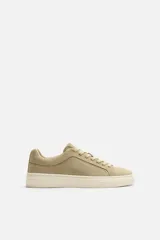 Zapatillas bajas color beige de piel serraje con cordones y suela plana color crema.