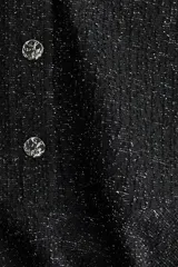 Vestido corto negro en tejido bouclé con hilos brillantes, escote en V, mangas tres cuartos y falda con vuelo.