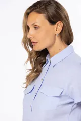Camisa color salmón de lino, de corte clásico, con cuello camisero, manga corta, cierre frontal con botones y dos bolsillos de parche en el pecho.