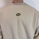 Buzo color beige de corte oversize con estampa en la espalda de botellas de vino y texto en verde.