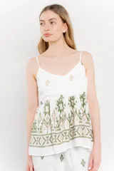 Blusa blanca de algodón con bordados artesanales en verde y corte suelto.