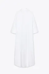 Vestido camisero largo color verde claro, confeccionado en lino. Tiene cuello solapa, escote en V, manga tres cuartos con trabilla y botón, bolsillos delanteros de plastrón, aberturas laterales en el ruedo y cierre frontal con botones.
