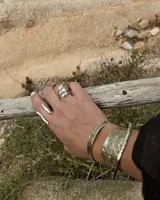 Anillo plateado con diseño abstracto y abierto, realizado en alpaca.