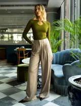 Pantalón palazzo de tiro alto color violeta, de satén. Tiene pretina delantera con pasadores, botón y cierre, pretina trasera elastizada y bolsillos verticales delanteros.