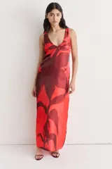 Vestido largo de seda con estampado floral abstracto en blanco sobre fondo negro, escote redondo y corte recto.