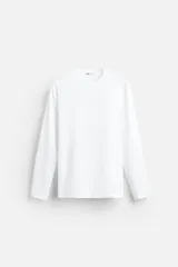 Camiseta blanca de manga larga y cuello redondo, corte ajustado.