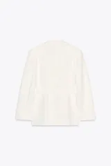 Blazer oversize color blanco confeccionado con 22% de lino. Tiene cuello solapa, manga larga con hombreras y abertura en la espalda. Incluye cinturón lazada en el mismo tejido.
