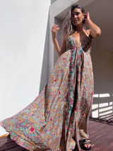 Vestido largo con estampado paisley en tonos marrones, celestes, dorados y fucsias. Tiene escote halter con tirantes finos y bordados rojos en el frente.