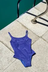 Traje de baño enterizo azul con breteles finos, escote en U y espalda redondeada.