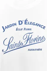 Camiseta blanca de cuello redondo y manga corta con estampado de texto en azul.