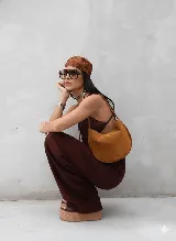 Cartera tipo hobo de gamuza color marrón claro con costuras a contratono.