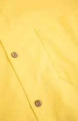 Camisa amarilla de algodón orgánico, manga larga con botones de madera, cuello italiano, calce regular, bolsillo de pecho con logo bordado.