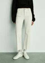 Pantalón de jean color crudo, de corte recto, con bolsillos frontales de parche y ruedo desflecado.