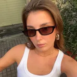 Lentes de sol unisex con montura rectangular negra y lentes marrones.