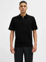 Polo negro de punto con cierre de cremallera, cuello polo y mangas cortas.