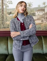 Blazer de tejido tweed en negro con escote mao, abertura central y puños con botones perlados.