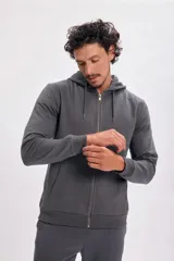 Campera deportiva gris oscuro con capucha y cierre frontal.