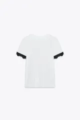 Camiseta blanca de algodón con cuello redondo y mangas cortas con detalle de encaje negro.