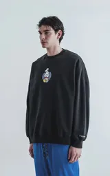 Buzo negro de frisa 100% algodón con calce oversize. Presenta un bordado frontal de Mickey Mouse vestido de chef, centrado sobre un círculo azul.