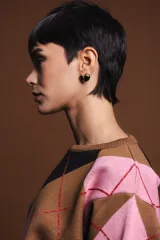 Aros dorados con detalle de esmalte negro en forma de corazón.