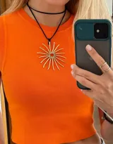 Collar con dije de sol hecho en bronce y cuero sintético, con tiento negro y cierre ajustable.