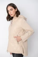Campera color beige con capucha, cierre frontal y diseño acolchado.