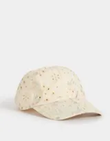 Gorra de béisbol color crema con bordado calado y estampado de flores en tonos pastel. Cuenta con visera curva y tira ajustable en la parte trasera.