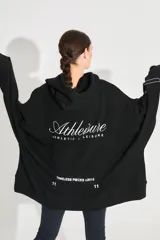 Buzo oversize negro de frisa esmerilada con capucha amplia, bolsillos laterales, terminaciones de puño y ruedo con rib, doble cordón con terminal termocontraíble y estampa serigrafiada en frente, manga y espalda con la palabra 'RENÉE'.