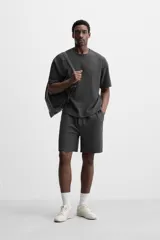 Bermuda negra de corte relaxed fit, con cintura elástica ajustable con cordón, bolsillos frontales y bolsillo trasero de parche.